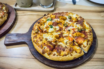 Hot Baked Pizza ready to eat serve on wooden board on table