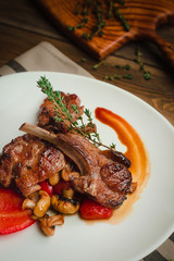 Grilled ribs with mushrooms, sweet peppers and thyme. Cafe menu on a wooden background in warm colors with copy space.