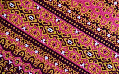 Close up detail of a pink and gold fabric from southeast Asia makes a beautiful background