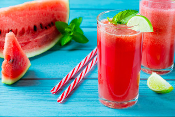 Watermelon juice on blue wood table with red tube.summer drink concept.