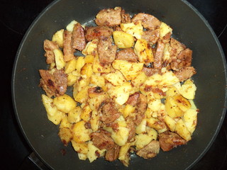 fried potatoes with meat in a pan