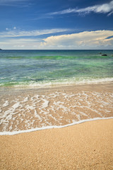 seascape with sand beach and wave bubble in blue skyline