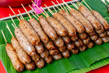 GRILL SAUSAGES - STREET FOOD : TRADITIONAL NORTH THAILAND SAUSAGE LAYING ON GREEN BANANA LEAF READY TO EAT AND SALE.