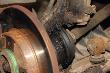 Normal brake disk and destroyed CV joint duster - repair car suspension and gear drive on left side with removed wheel