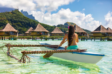 Outrigger Canoe - woman paddling in traditional Polynesian Outrigger Canoe - obrazy, fototapety, plakaty