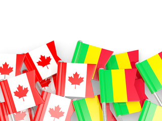 Pins with flags of Canada and mali isolated on white.