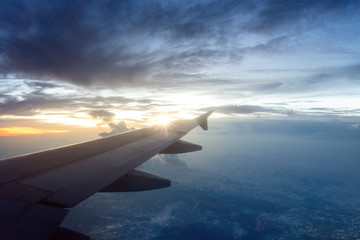 Fototapeta na wymiar Flugzeug über den Wolken bei Sonnenaufgang