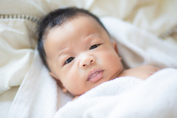 Infant baby boy lying on white blanket