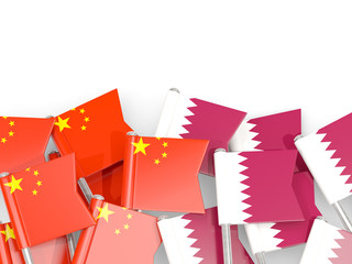 Pins with flags of China and qatar isolated on white.