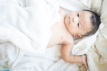 Infant baby boy lying on white blanket