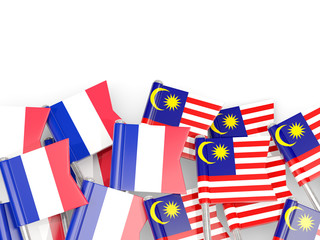 Pins with flags of France and malaysia isolated on white.