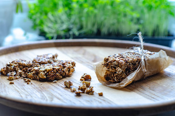 Healthy sweet bars with nuts, sesame, cereals and honey on the rustic wood table background. Proper nutrition. Superfood