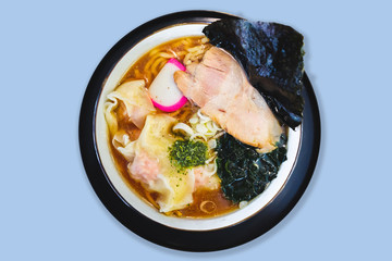 Isolated top view of Ramen Pork Bone Soup (Tonkotsu Ramen) with Chashu Pork, Scallion, Wanton, Menma (Seasoned Bamboo Shoots), Dried Seaweed in blue background.