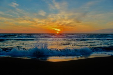 Beautiful sunset at the beach with waves