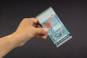 Hand holding Malaysia Ringgit MYR Currency Bank Notes. Selective focus