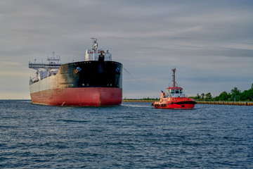 The Port of Gdansk, Poland, tugs enter the port of a large merchant ship