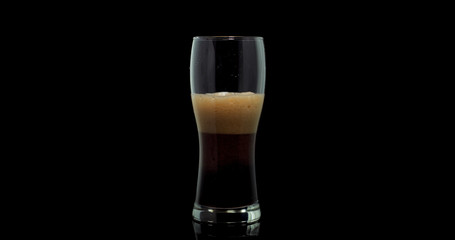 black craft beer in a glass on a isolated background
