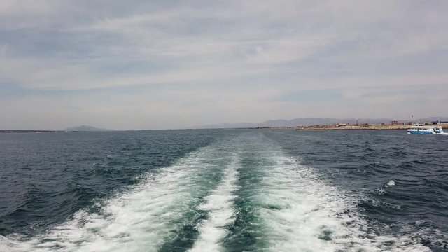 The ferry from the Spanish port of Santa Pola is on its way to the small island of Tabarca. At the stern you can see the wake and another ferry in the opposite direction.