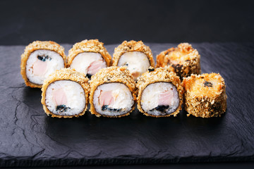 Japanese sushi tempura maki grouper and tobiko roll on  slate. Japanese traditional fusion food...