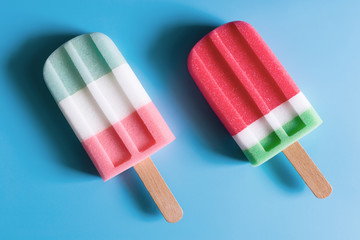 Flat lay of colorful ice cream on the modern rustic on blue background at home office desk wallpaper, top view colorful ice cream pattern on blue pastel background. Minimal summer concept.