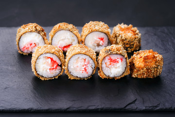 Japanese sushi tempura maki crab meat and tobiko roll on  slate. Japanese traditional fusion food style, restaurant menu