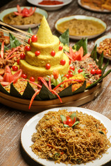 Nasi Tumpeng. Yellow rice in a cone shape. A festive Indonesian rice dish with side dishes.