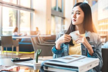 Asian woman in a cafe drinking coffee .Portrait of Asian woman smiling in coffee shop cafe vintage color tone.