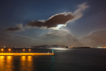 Naklejka na ściany i meble Moon rays illuminating the sea in front of the port of Piraeus