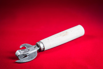 Classic old can opener on a plain background