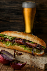Home cooking sandwich with your hands on a dark wooden background.