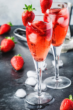 Rossini alcoholic cocktail with Italian sparkling wine, strawberry puree and ice in champagne glasses, place for text, selective focus