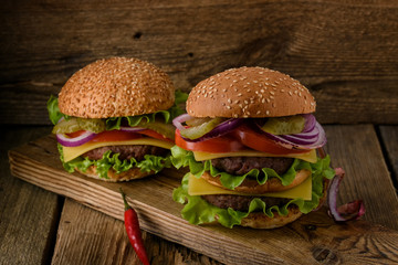 Home cooking burgers on a dark wooden background.