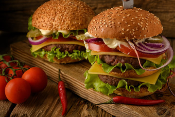 Home cooking burgers оn a dark wooden background.