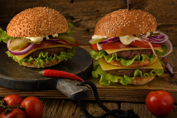 Home cooking burgers on a dark wooden background.