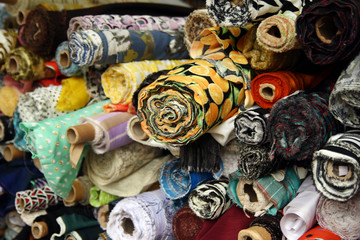 Fototapeta na wymiar Multicolored fabrics for sale in the shop window.