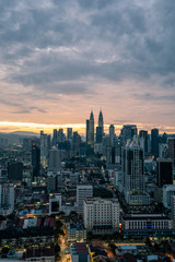 KUALA LUMPUR, MALAYSIA - February 20 2019: Petronas Twin Towers just before sunrise with a bright moody sky.