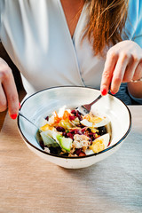 woman eating tuna salad with egg and olives