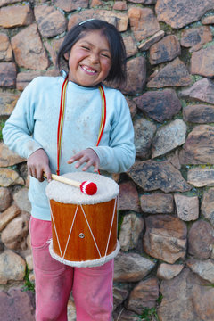 Little native american girl playing traditional sikuri drum.