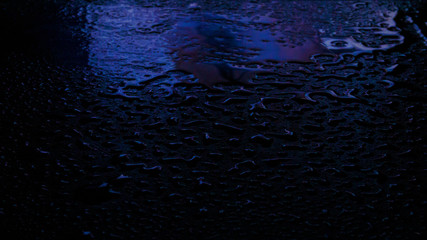 Wet asphalt, night scene of an empty street with a little reflection in the water, the night after the rain. Abstract dark neon background with a wet surface, reflection, neon, glare, blurred bokeh.