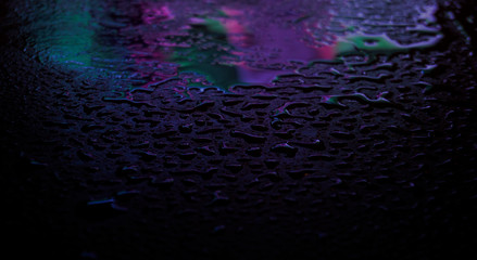 Wet asphalt, night scene of an empty street with a little reflection in the water, the night after the rain. Abstract dark neon background with a wet surface, reflection, neon, glare, blurred bokeh.