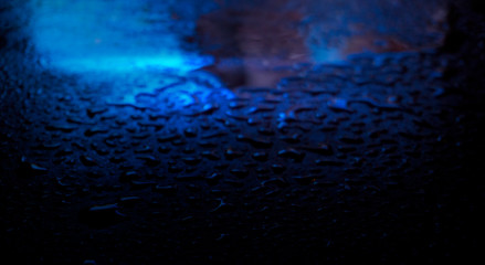 Wet asphalt, night scene of an empty street with a little reflection in the water, the night after the rain. Abstract dark neon background with a wet surface, reflection, neon, glare, blurred bokeh.