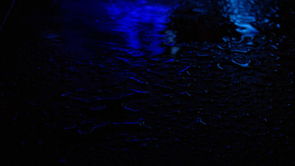Wet asphalt, night scene of an empty street with a little reflection in the water, the night after the rain. Abstract dark neon background with a wet surface, reflection, neon, glare, blurred bokeh.