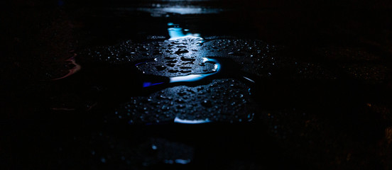 Wet asphalt, night scene of an empty street with a little reflection in the water, the night after...