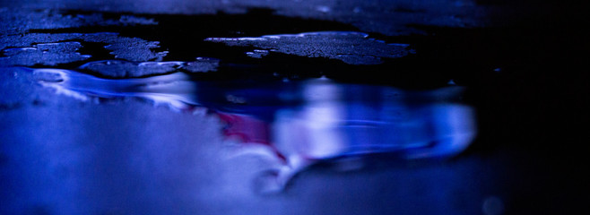 Wet asphalt, night scene of an empty street with a little reflection in the water, the night after...