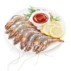 Raw shrimps in white plate with lemon and tomato sauce. isolated on white background