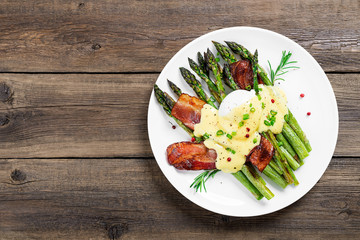 Grilled Asparagus served with poached egg, bacon  and  hollandaise sauce, top view.