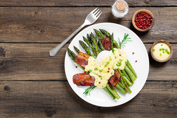 Grilled Asparagus served with poached egg, bacon  and  hollandaise sauce, top view.