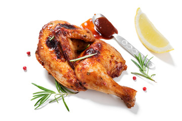 Halves of appetizing grilled juicy chicken with golden brown crust served with lemon...