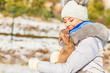 Woman playing with dog during winter