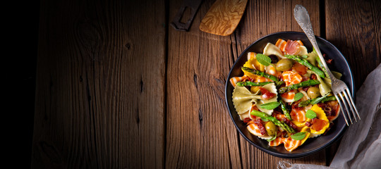 Pasta salad with green asparagus, olives and parma ham